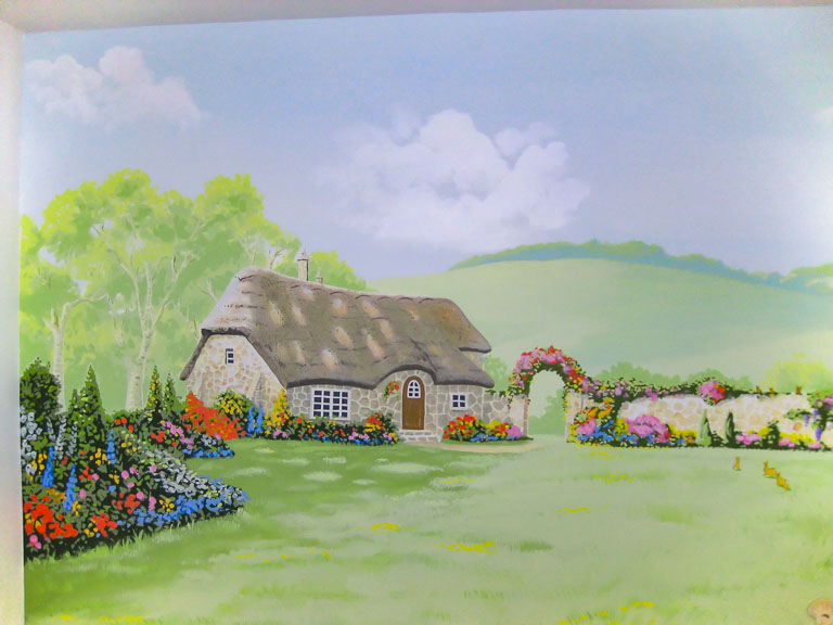 beatrix potter style mural with thatched cottage