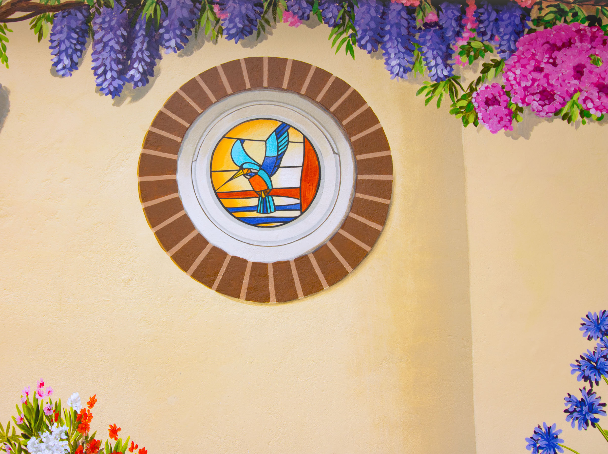 Trompe L'oeil circular brick window, with internally lit stained glass kingfisher