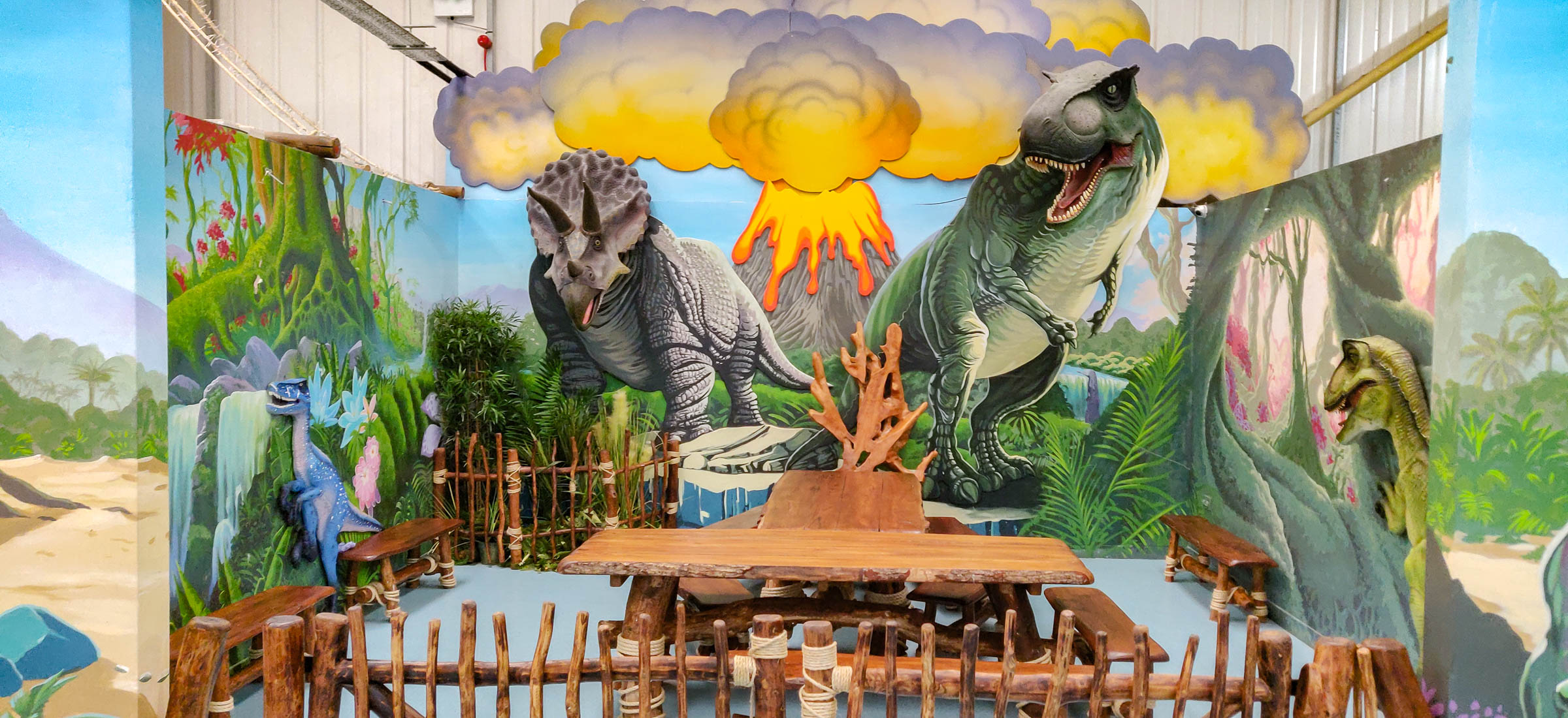 Dinosaur room centre piece for photo shoots with T-Rex and Triceratops, whose heads are real models, very large and life-like which are securely attached to the walls. My task was to paint in their bodies on the flat wall behind, and place them in a scene.