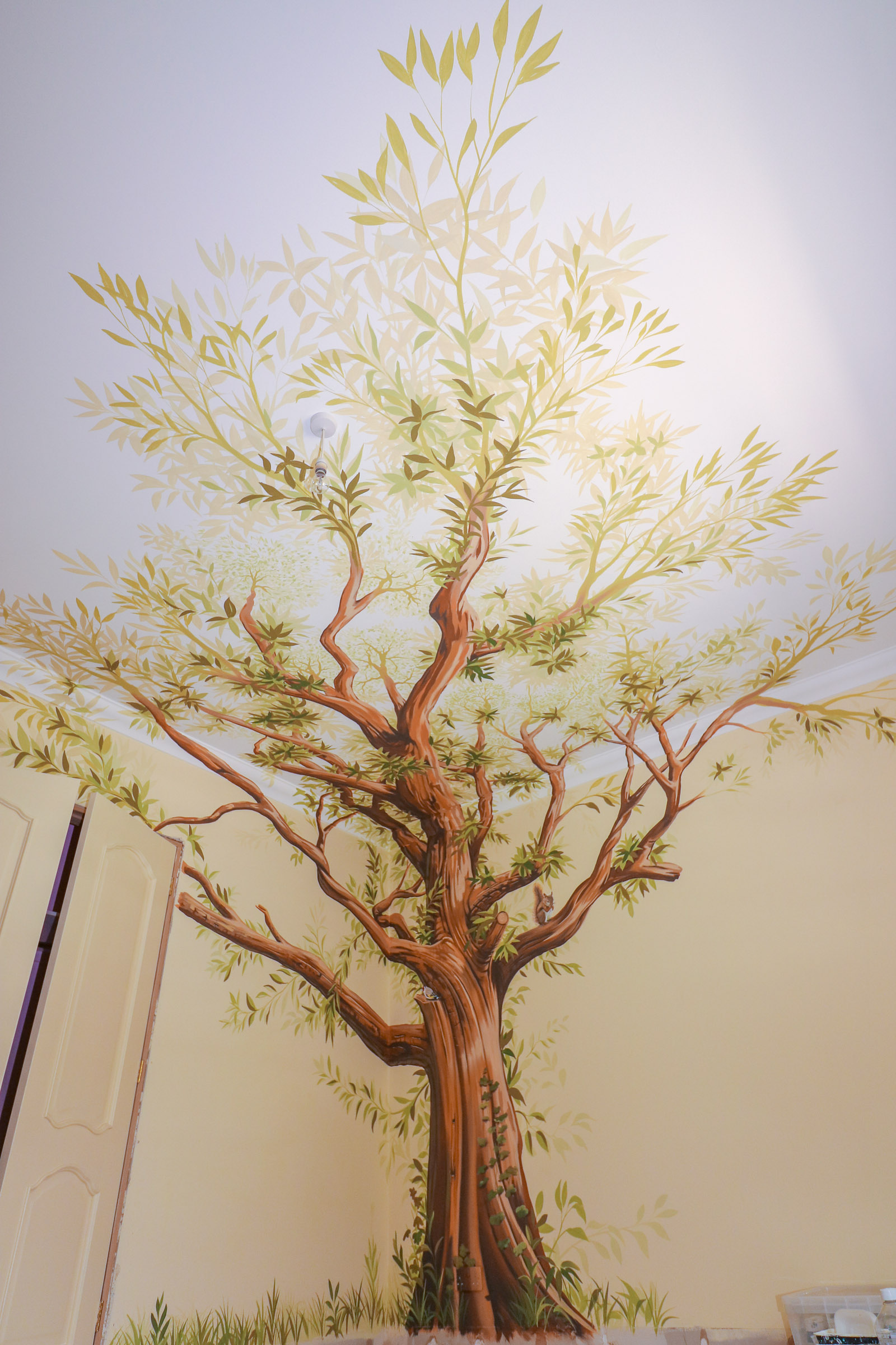 Wonderful tree mural painted on the walls and ceiling in this bedroom decoration idea