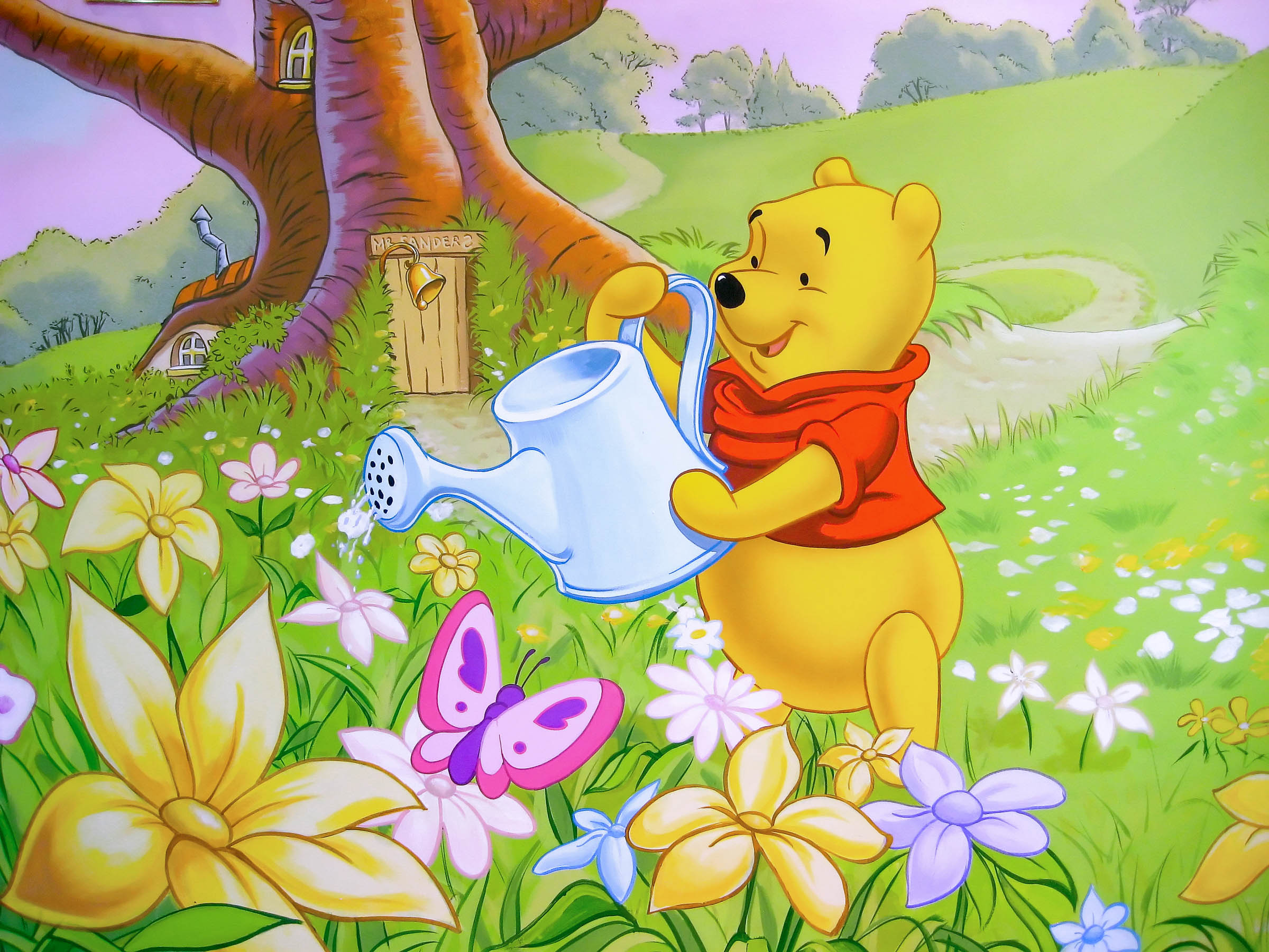 Winnie the Pooh watering the flowers outside his Sanders house