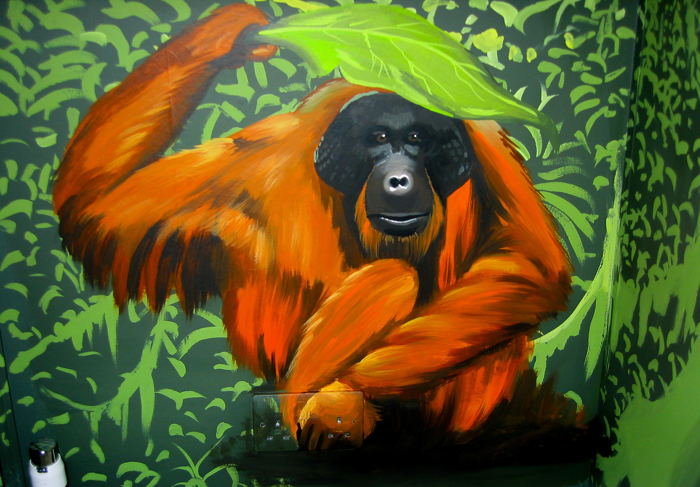 Shy orangutan hiding under a leaf in this  mural for kids room