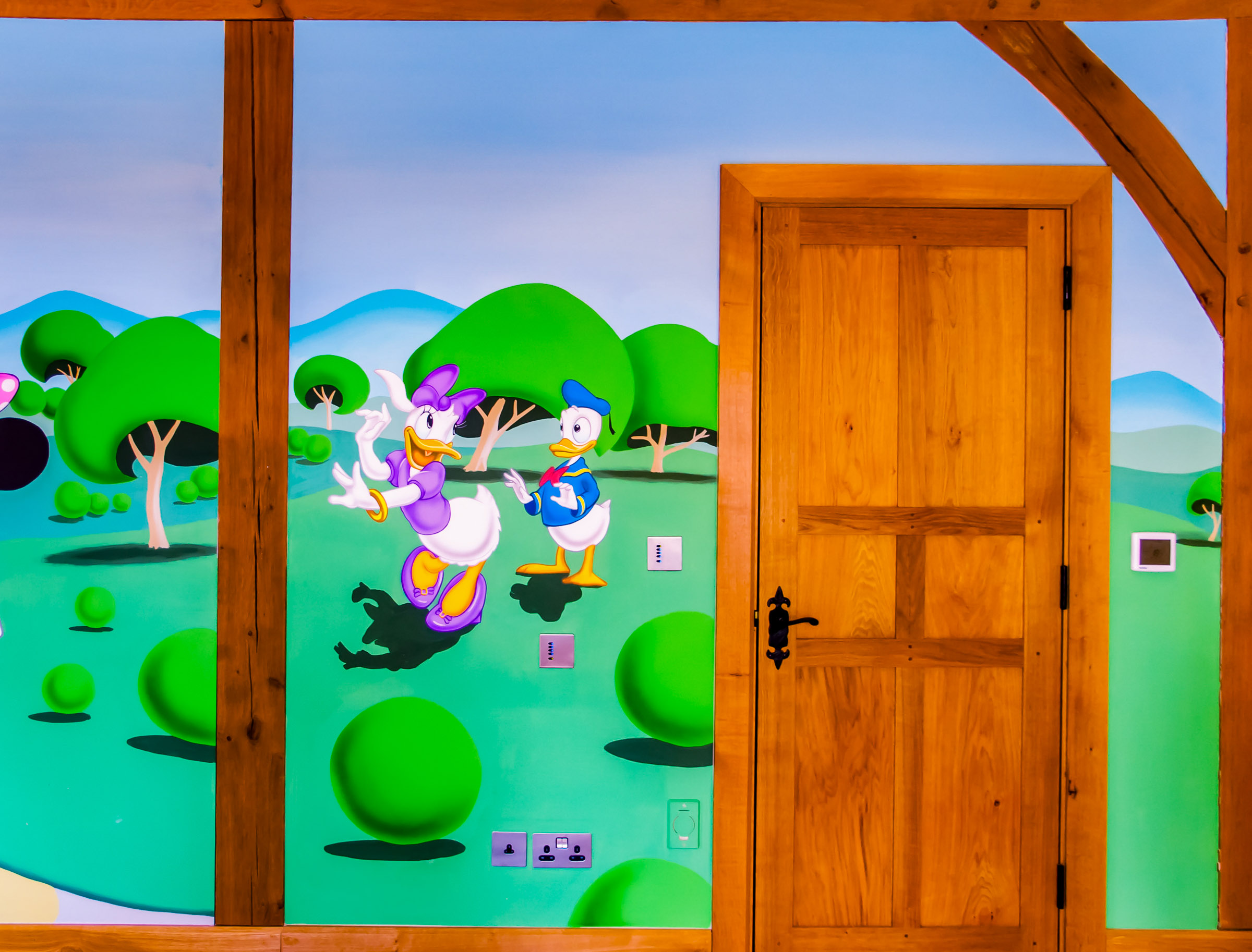 Donald Duck and Daisy Duck in the right hand side of the mural, hand-painted around the door and exposed beams